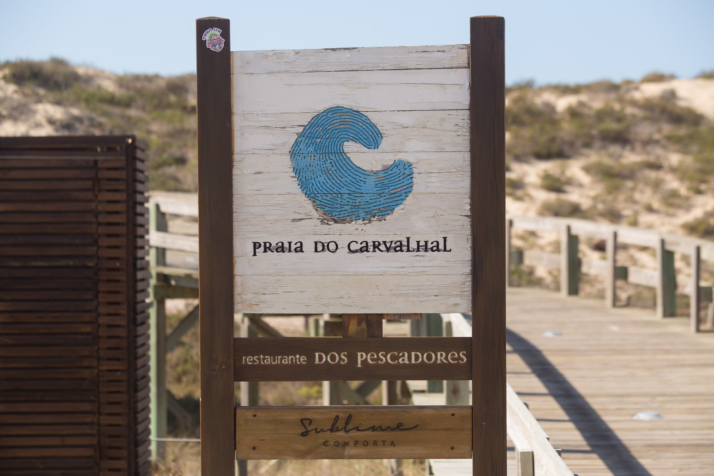 Un chemin d'accès en bois mène par-dessus les dunes à la plage de Praia do Carvalhal.
