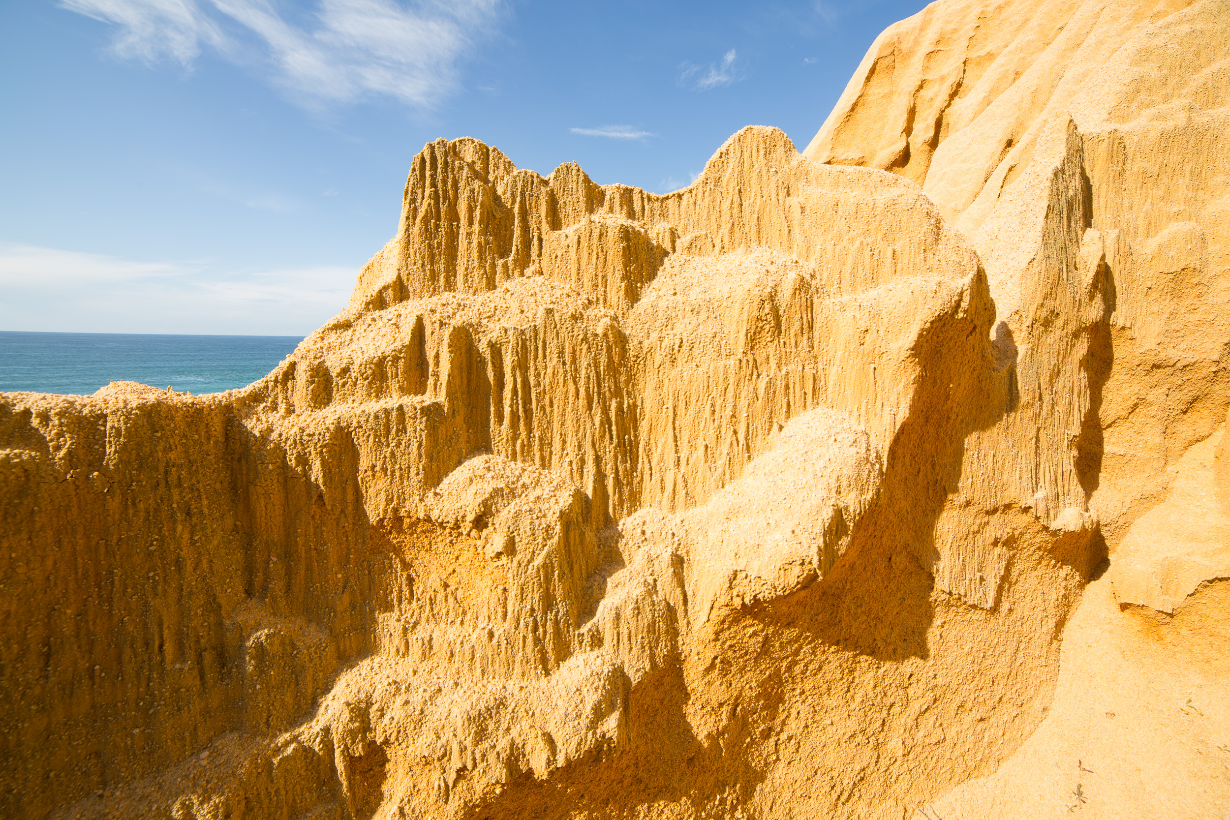 Formations rocheuses sculpturales en grès, presque polies, sous la chaude lumière du soleil.