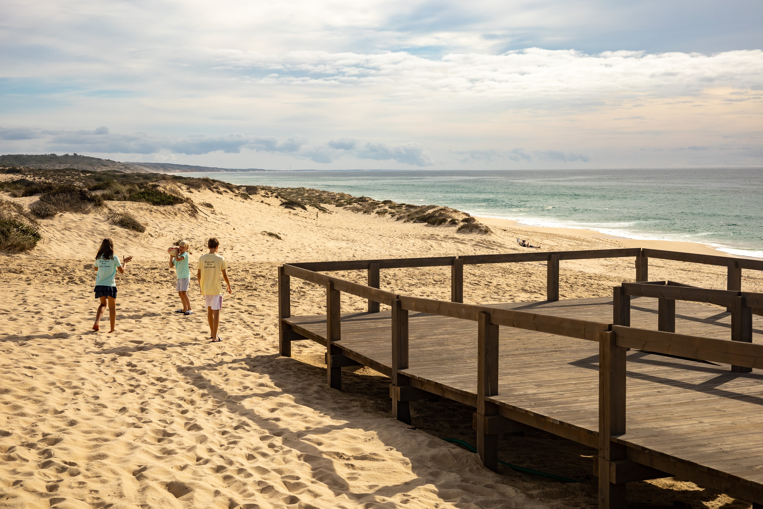 Dunes et plage de sable dans la lumière chaude du soleil couchant.