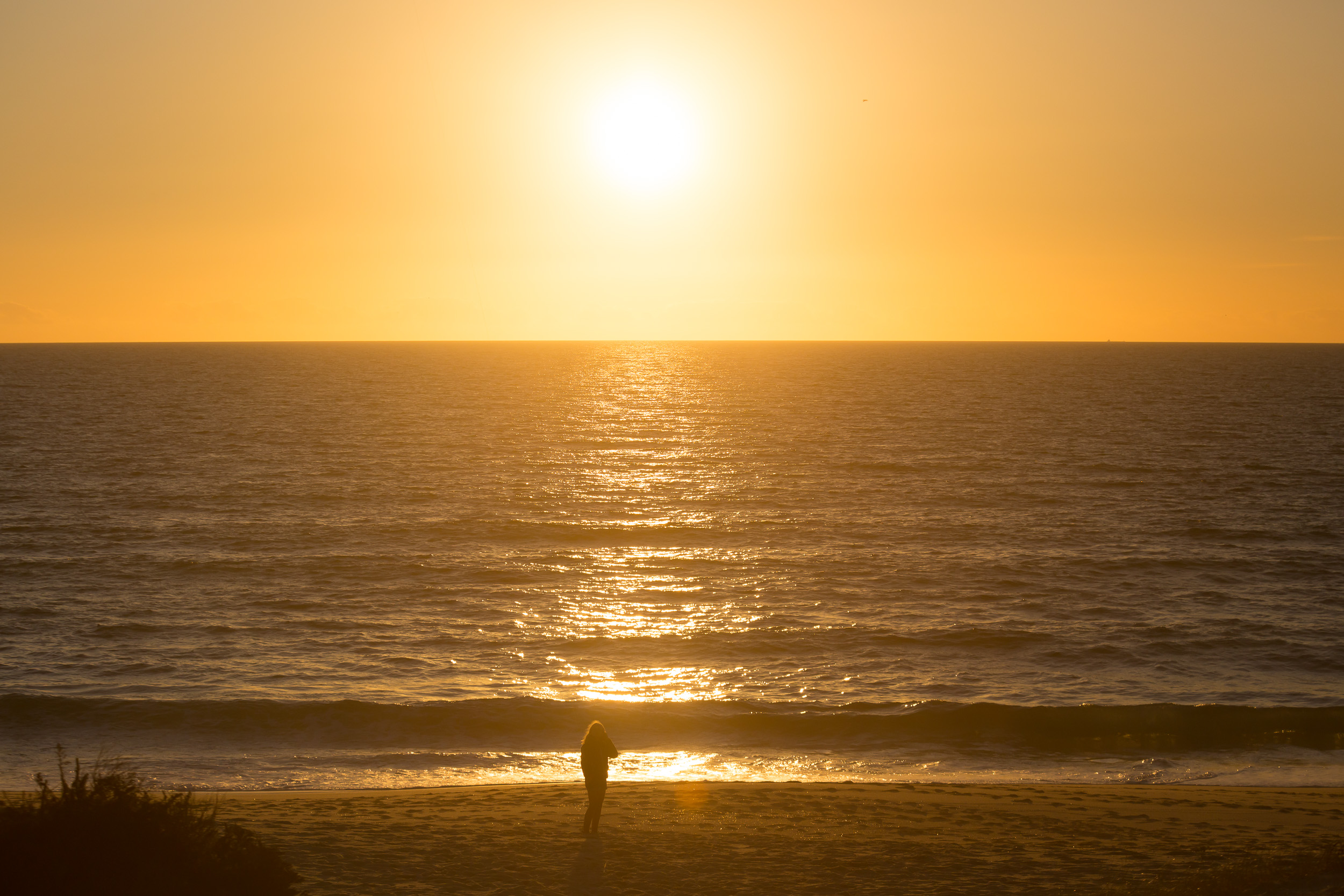 L'horizon de l'Atlantique brille aux couleurs du soleil couchant.