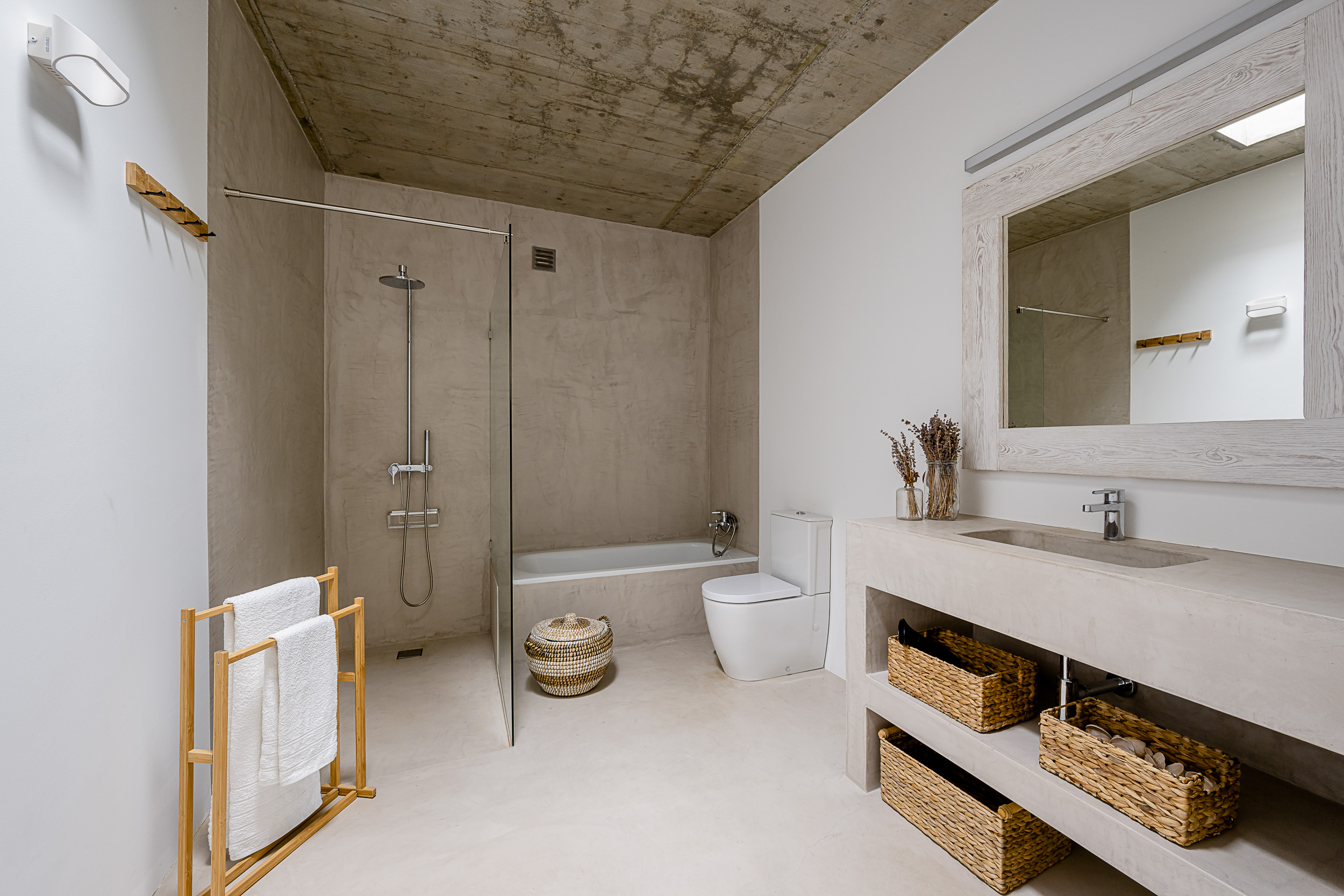 Ein helles, modernes Badezimmer mit ebenerdiger Dusche und großem Fenster