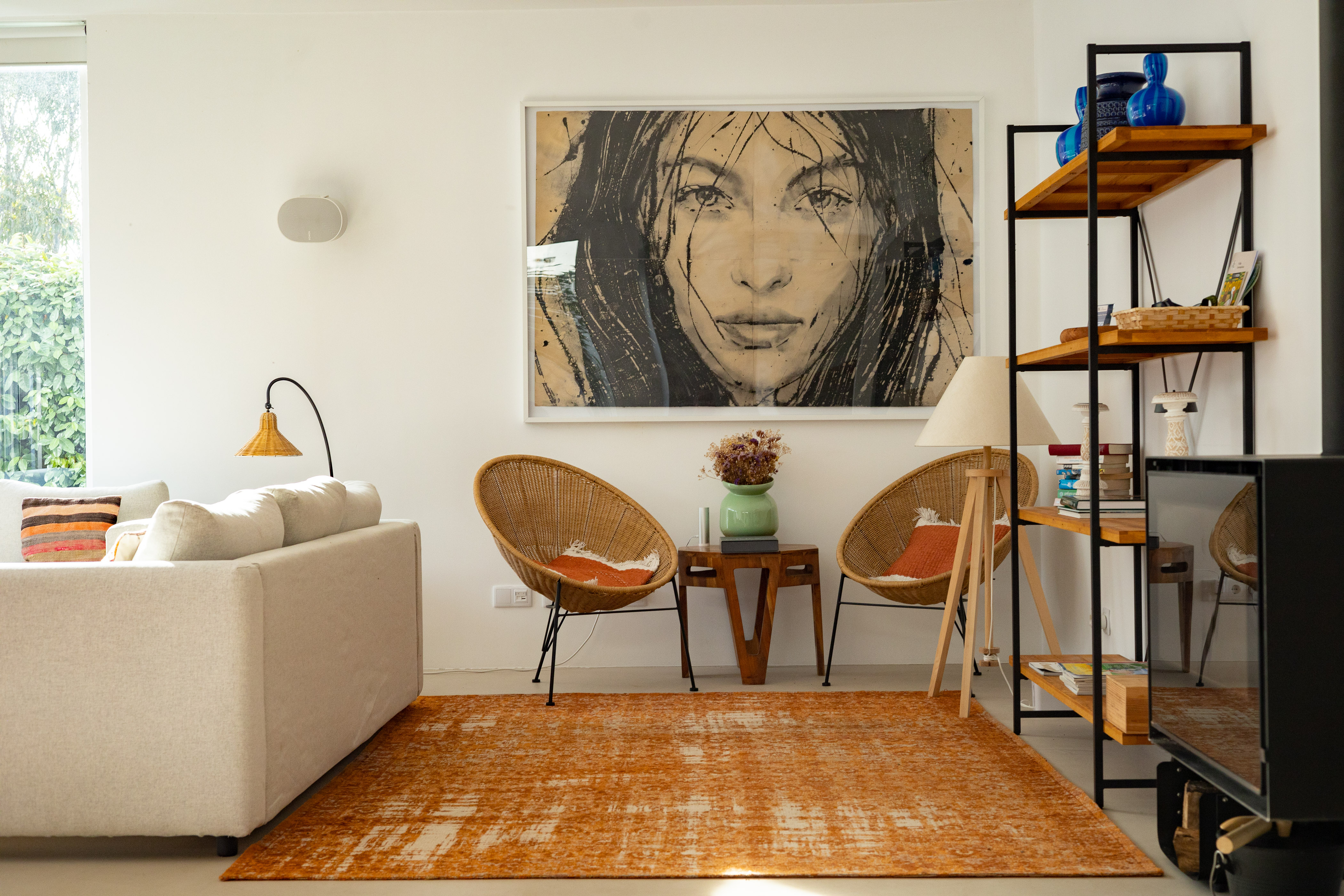 Ein stilvoller Lesebereich im Wohnzimmer mit einem auffälligen Frauenporträt an der Wand
