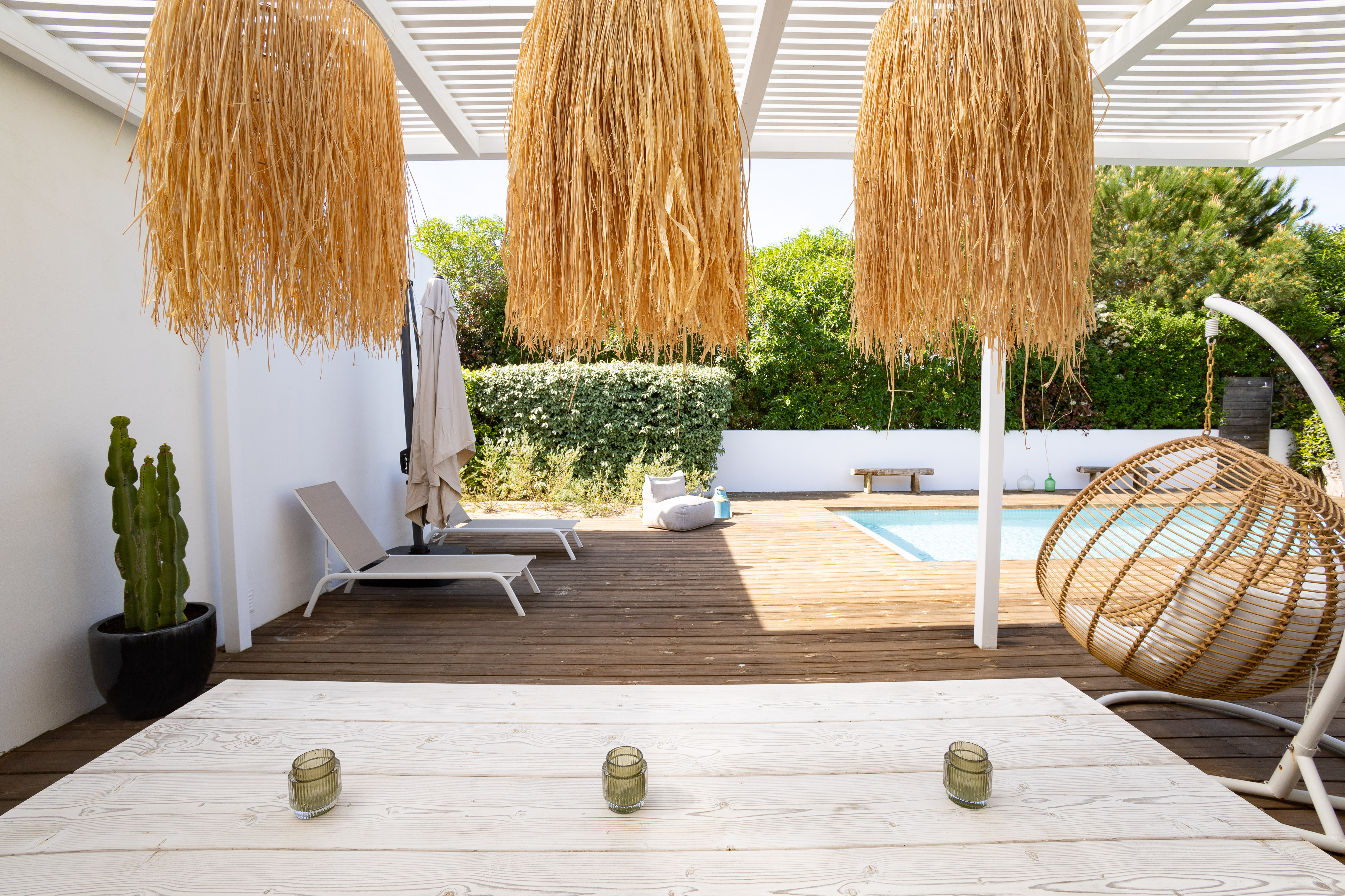 Eine moderne, überdachte Außenküche mit Grill und Esstisch auf der Terrasse