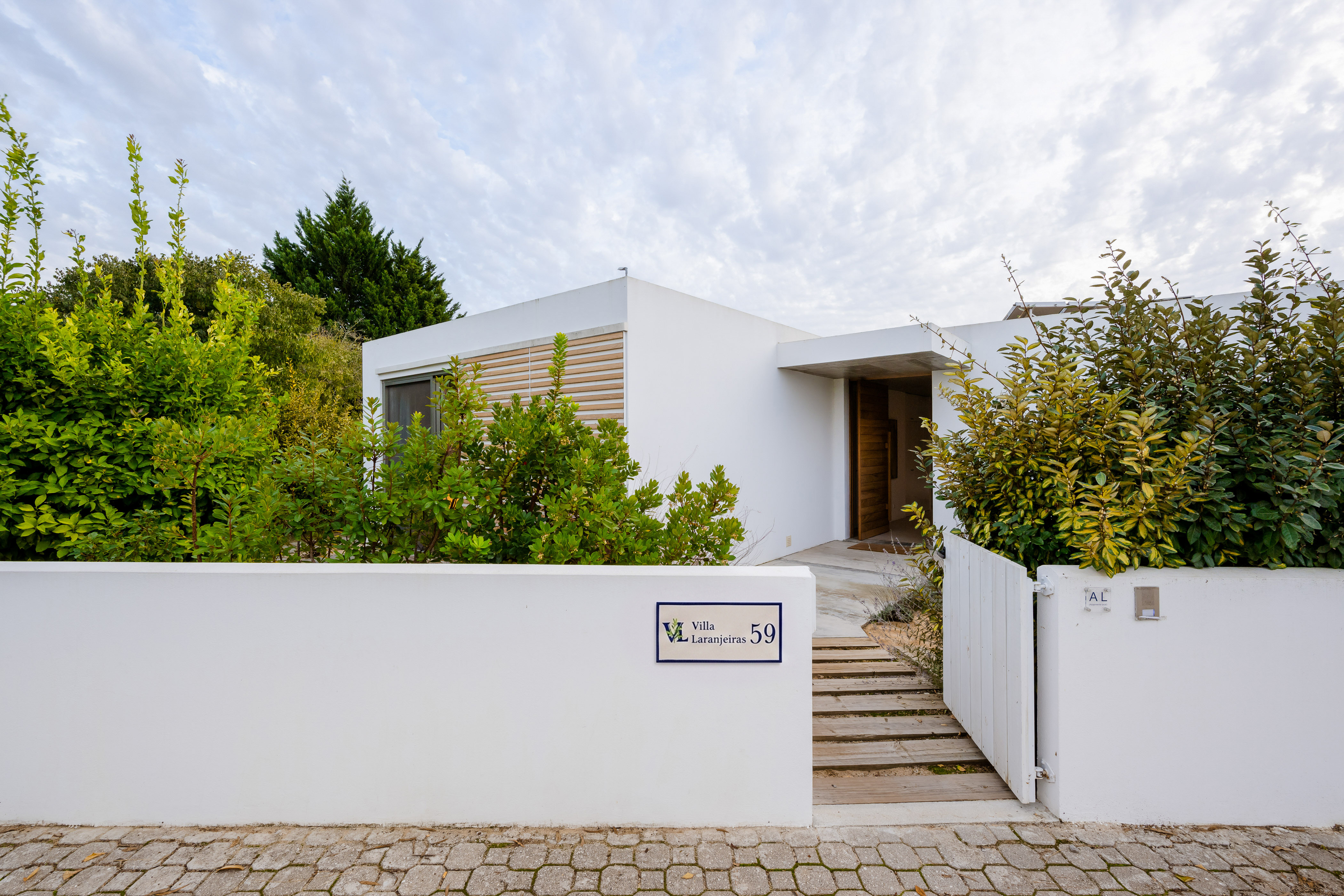 Der weiße, moderne Eingangsbereich der Villa Laranjeiras mit einer eleganten Hausnummer