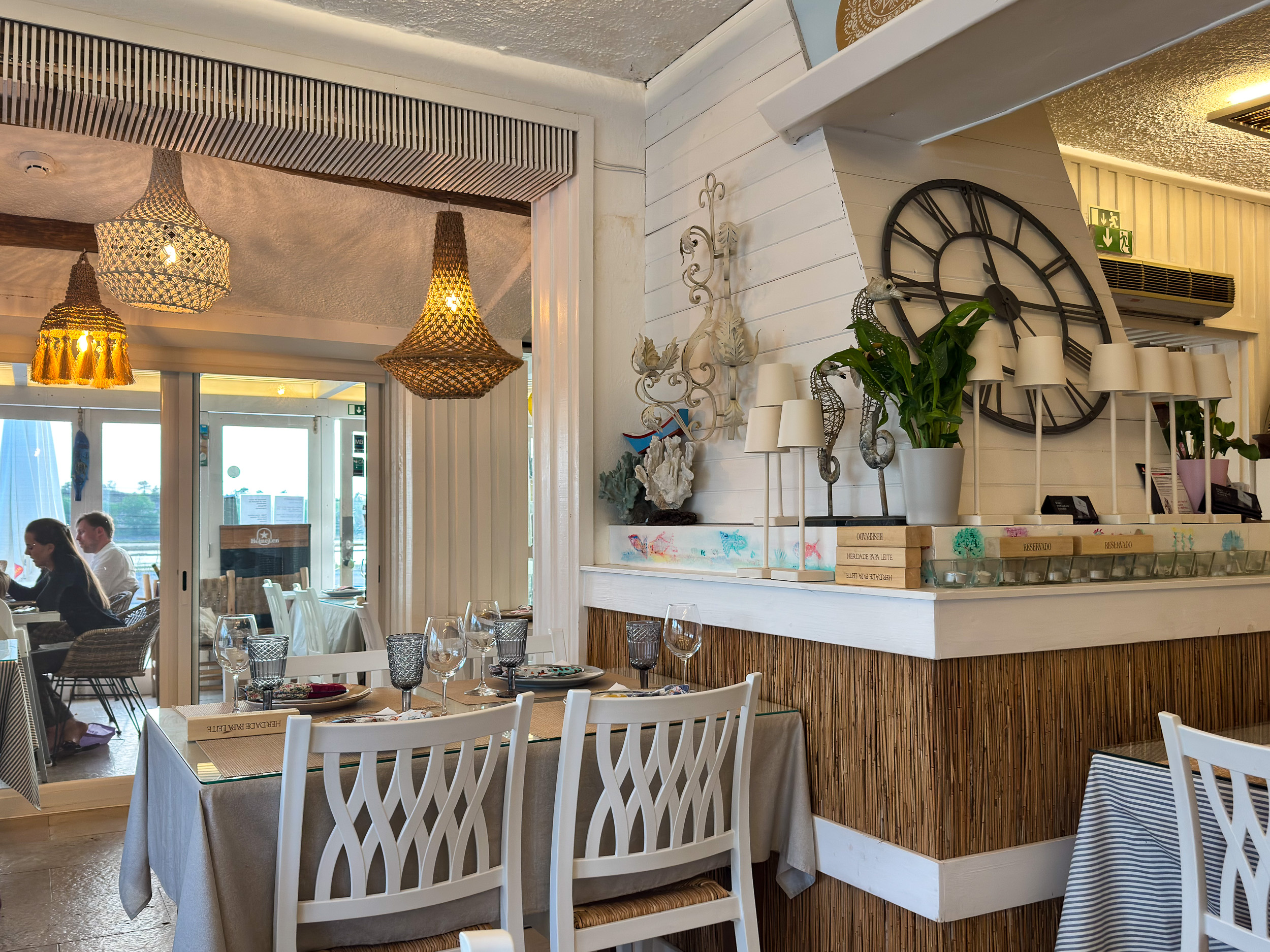 Une salle à manger lumineuse et accueillante avec des chaises en bois confortables et des détails de décoration maritime. Alentejo et accueil chaleureux