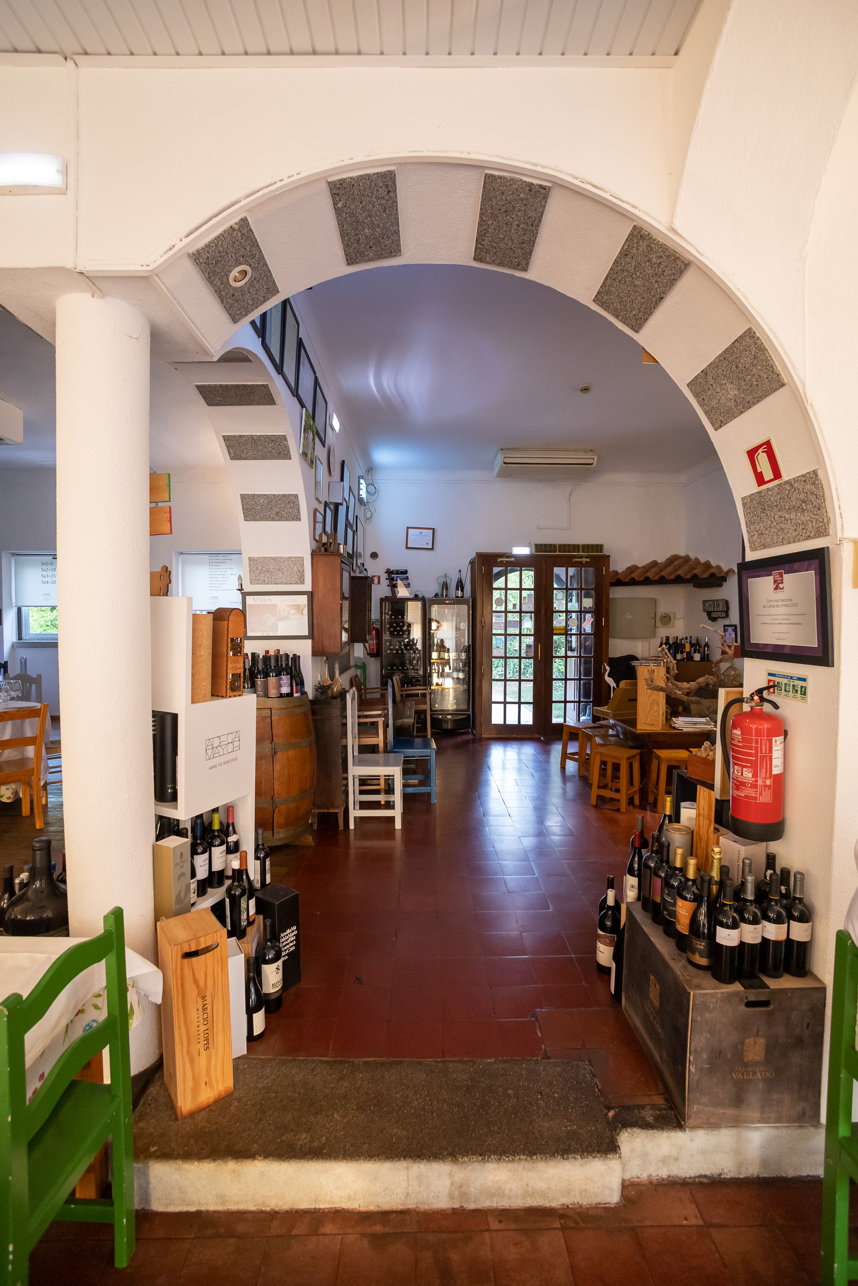 Une salle à manger rustique avec des arches en pierre historiques et des tables en bois dressées dans l'ancien bâtiment de l'école. une ancienne école de village