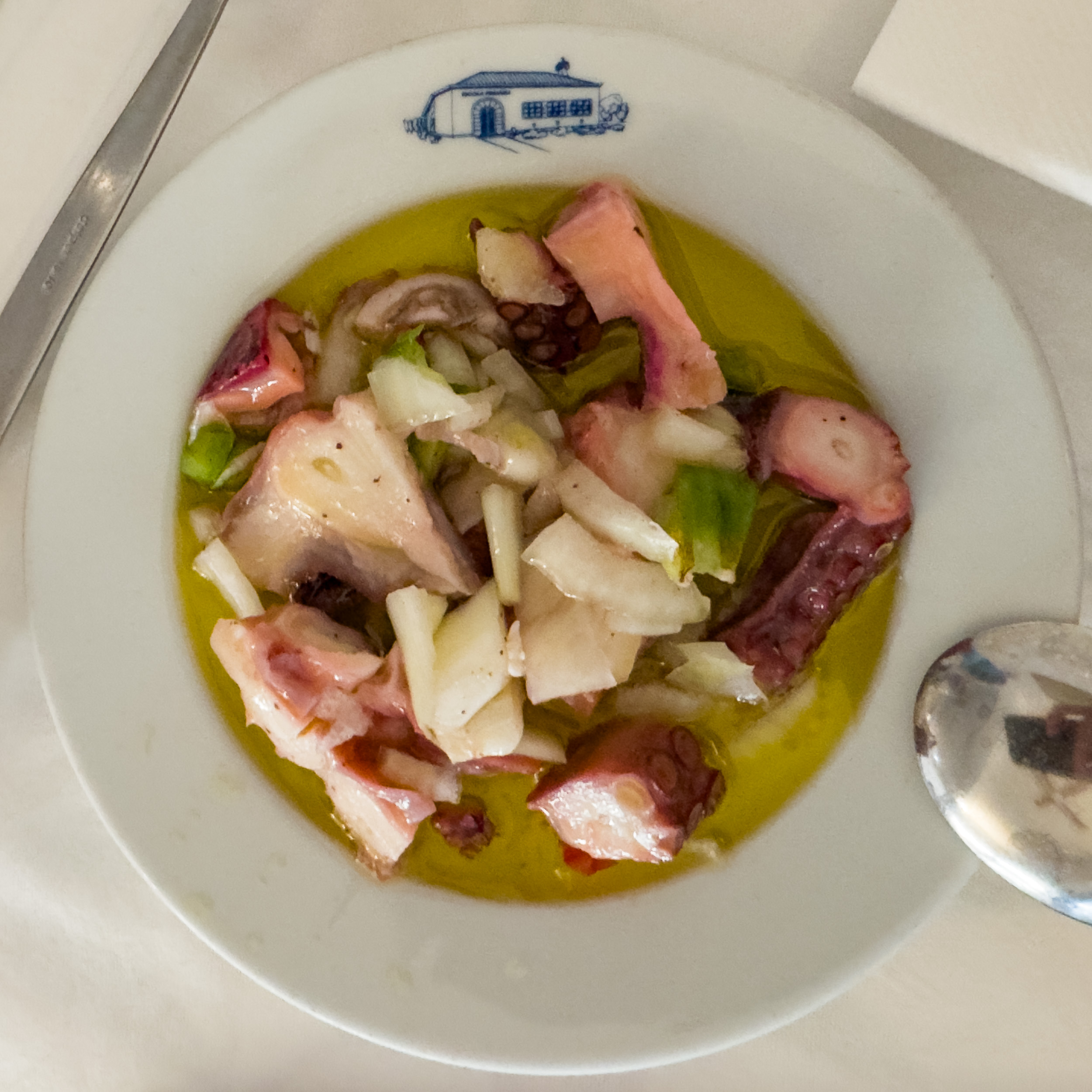 Un bol de salade de poulpe portugaise classique, marinée dans beaucoup d'huile d'olive avec des herbes fraîches. Alcácer do Sal