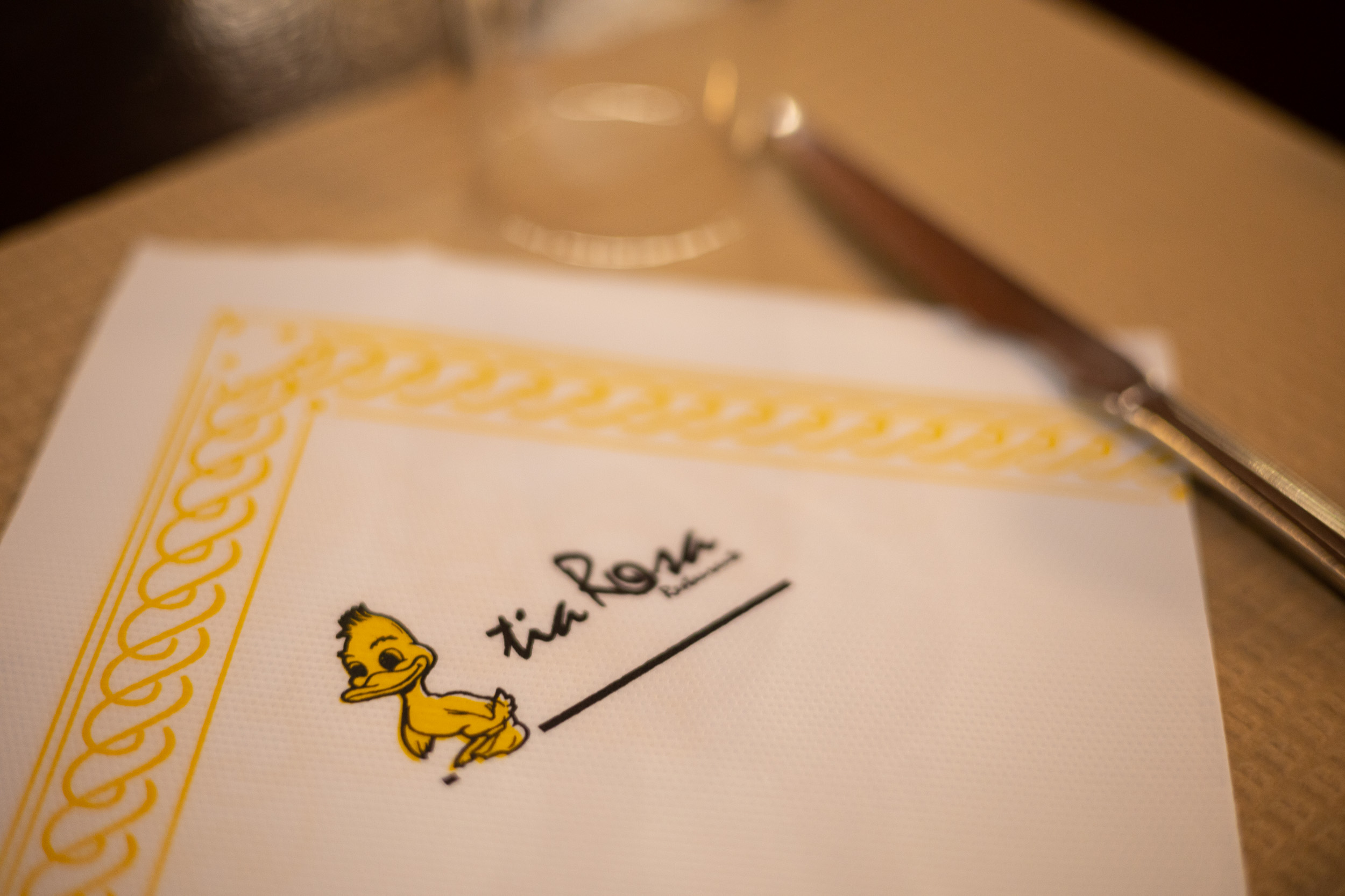 Gros plan d'une serviette en papier imprimée avec le logo souriant du restaurant Tia Rosa.