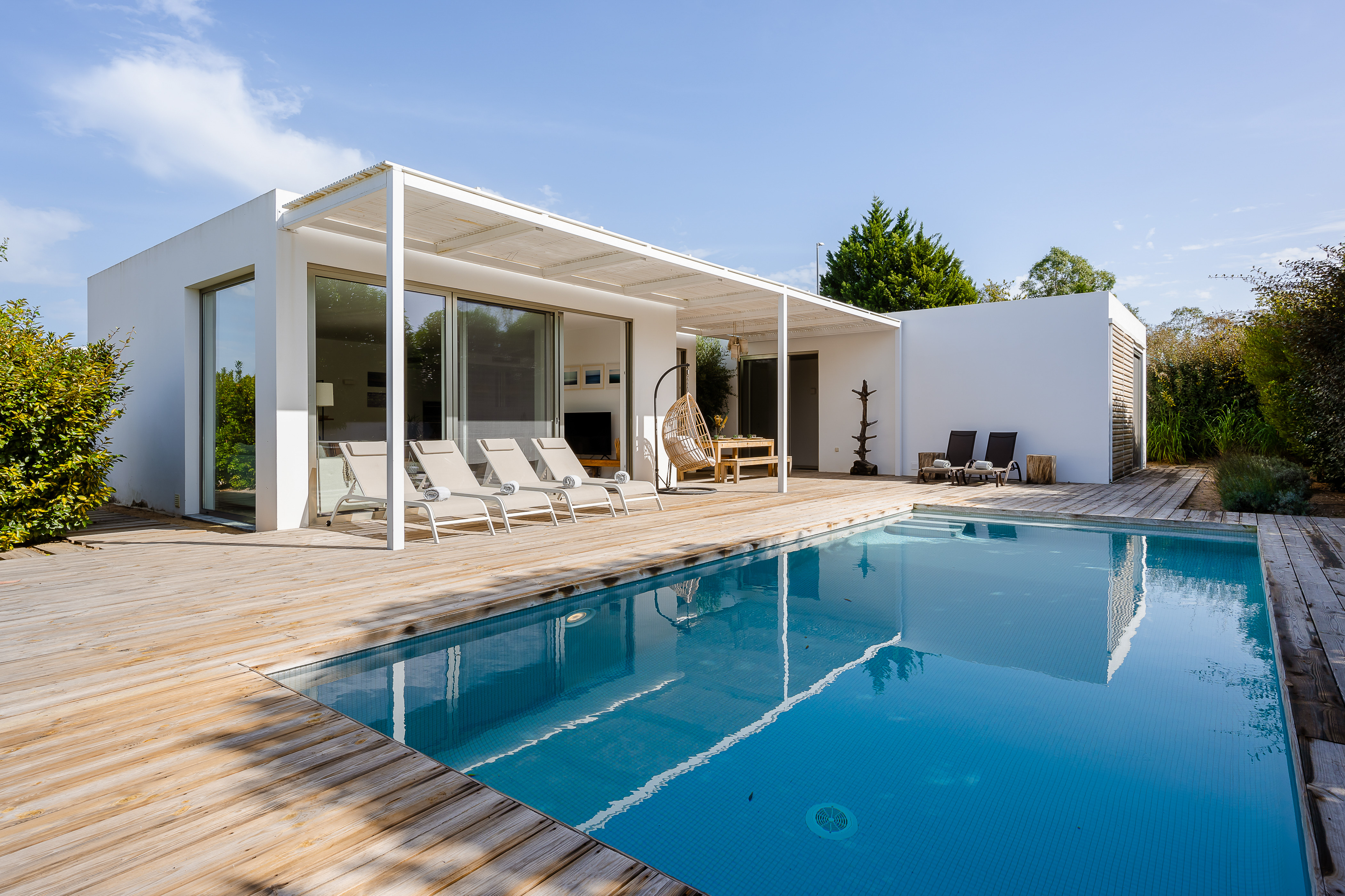 Blick von Südosten auf die moderne Villa Laranjeiras mit ihrer sonnenüberfluteten Holzterrasse und dem privaten Swimmingpool.