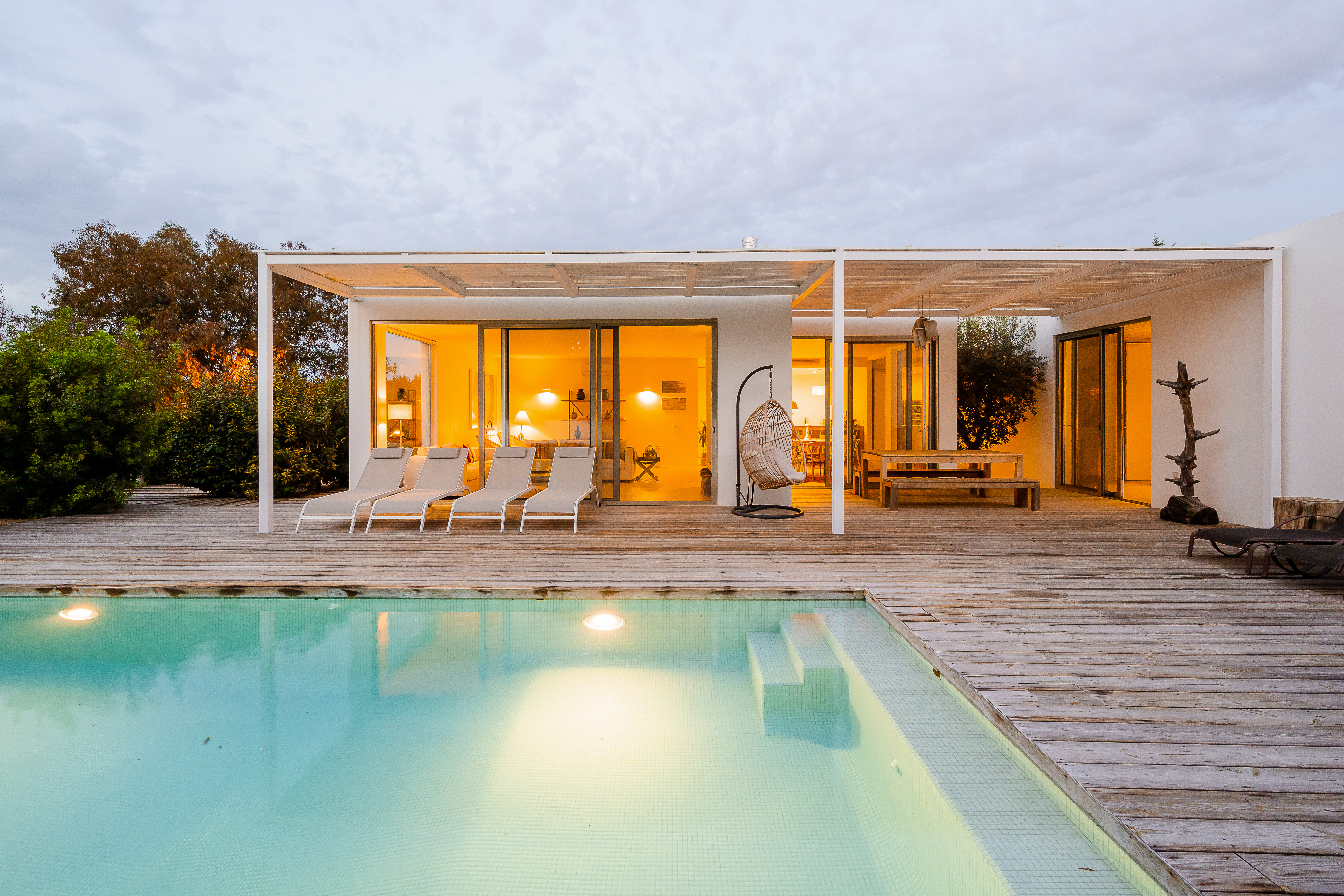 Stimmungsvolle abendliche Beleuchtung der Poolterrasse und der Außenfassade