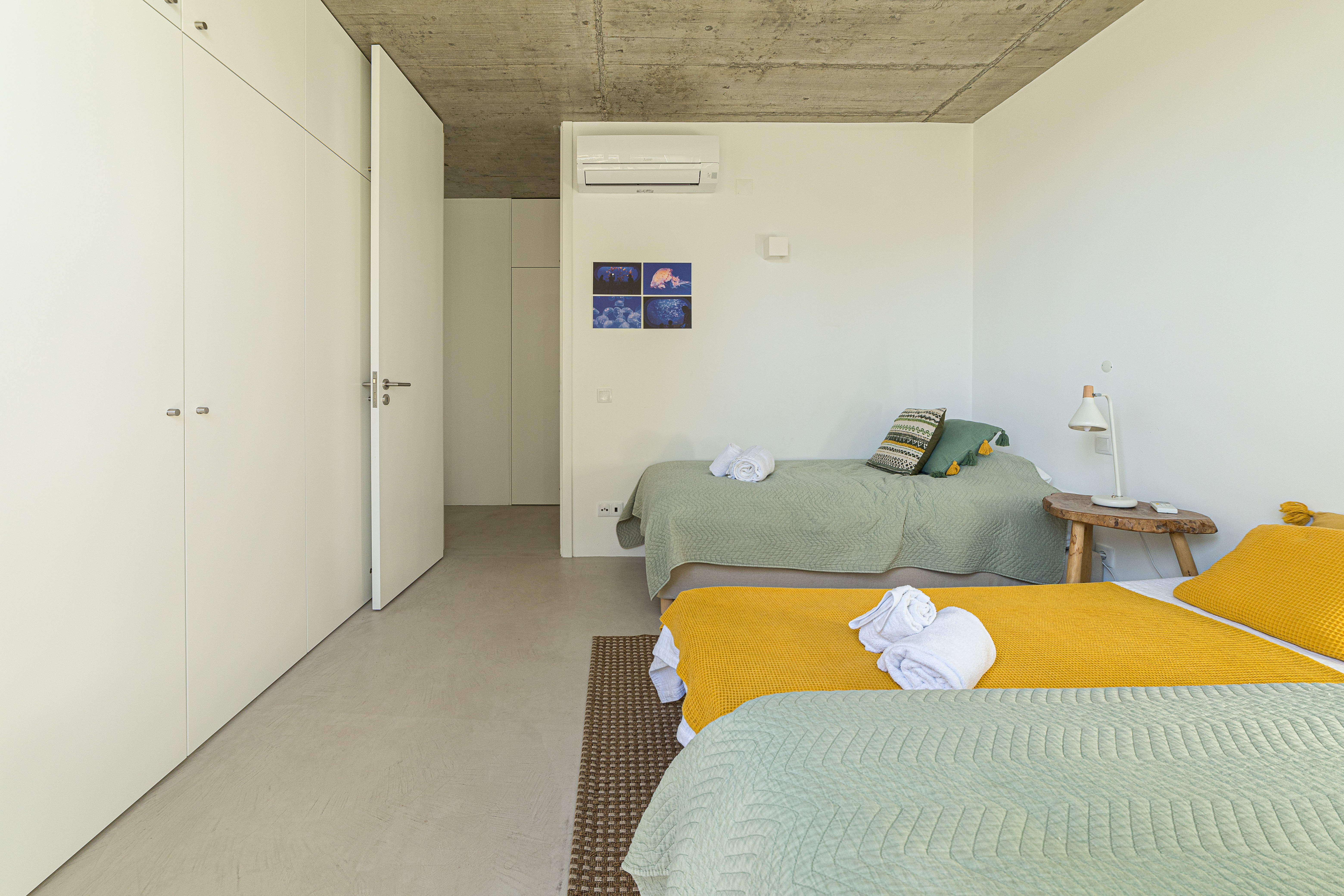 Ein funktionales Zweibettzimmer mit Einbauschränken und einem großen Fenster zum Garten