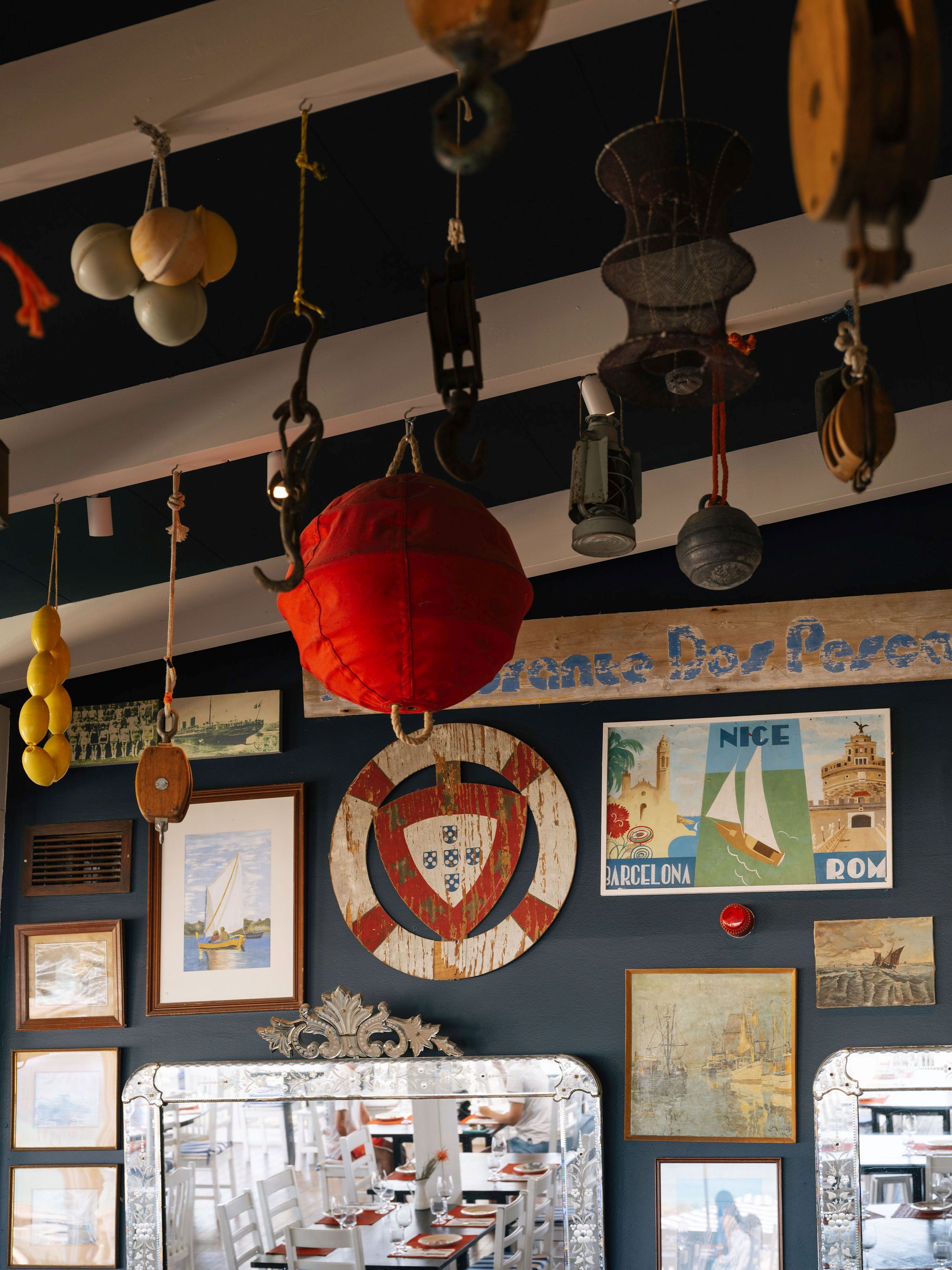 Nautisches Interieur des Restaurante Sal — Fischerbojen und historische Gemälde an dunkelblauer Wand